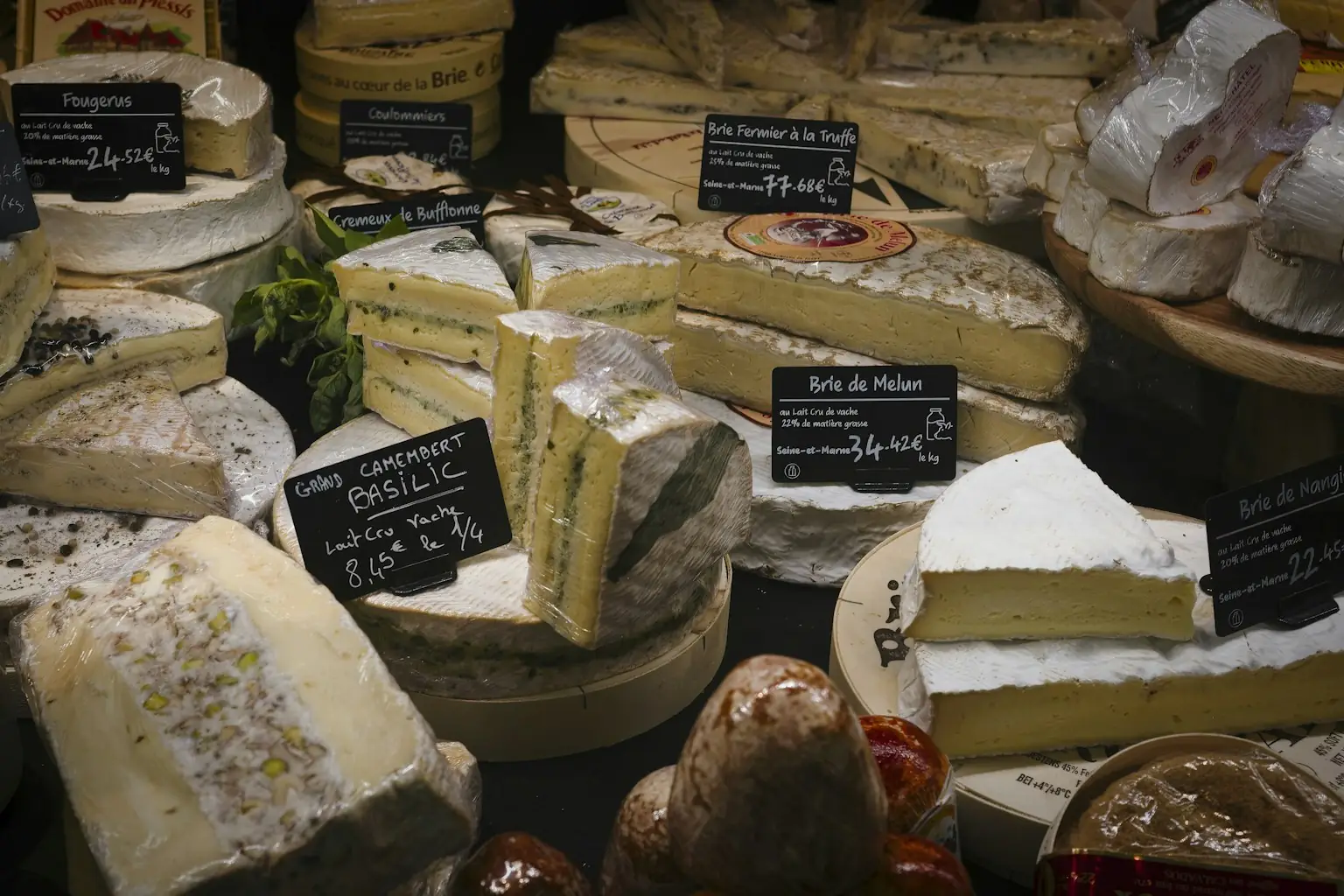 Mostrador de quesos con brie y camembert de leche cruda etiquetados con su precio